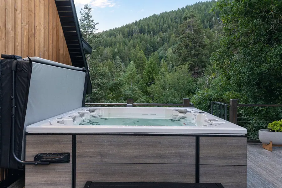 Matterhorn Hygge House deck hot tub overlooking dense forest hillside