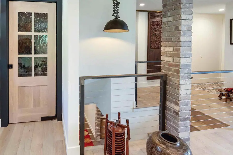 Wallace Project upper hall with cable rail, brick column, and glass-panel door