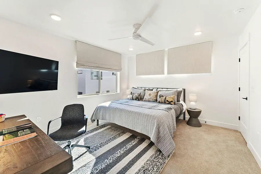 Silver Creek bedroom with striped rug, gray bedding, and fabric wall panels