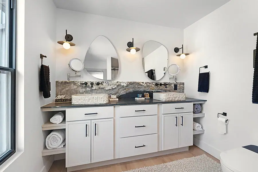 Little Gem double vanity with stone vessel sinks, organic mirrors, and white cabinetry