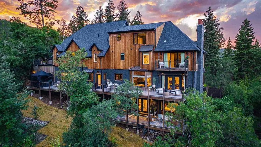 Matterhorn Hygge House rear decks and wood facade glowing under dramatic sunset sky
