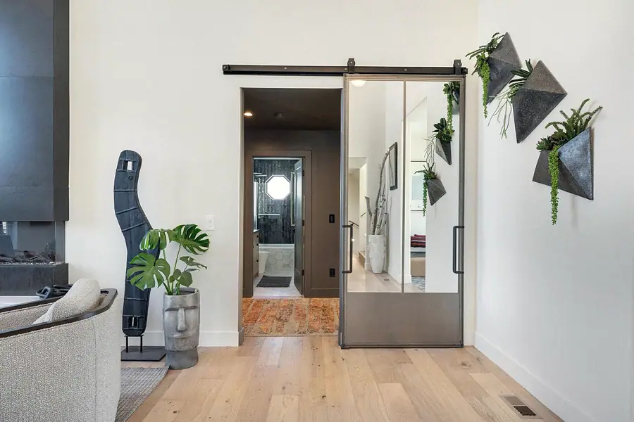 Mirrored barn door, living wall planters, and hallway toward the bath