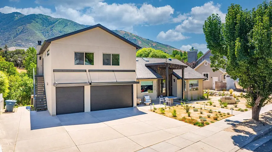 Elysium front exterior with two-car garage, xeriscape entry, and mountain backdrop