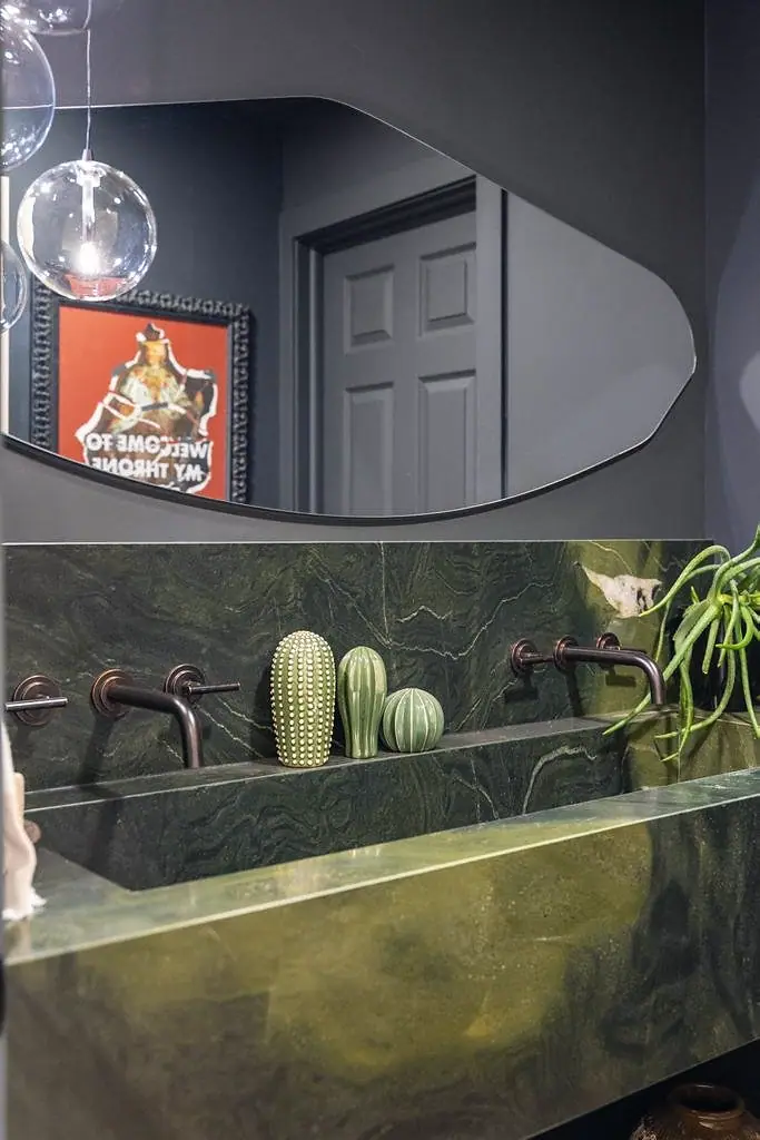 Crista da Montanha green marble double sink with bronze wall faucets and organic mirror