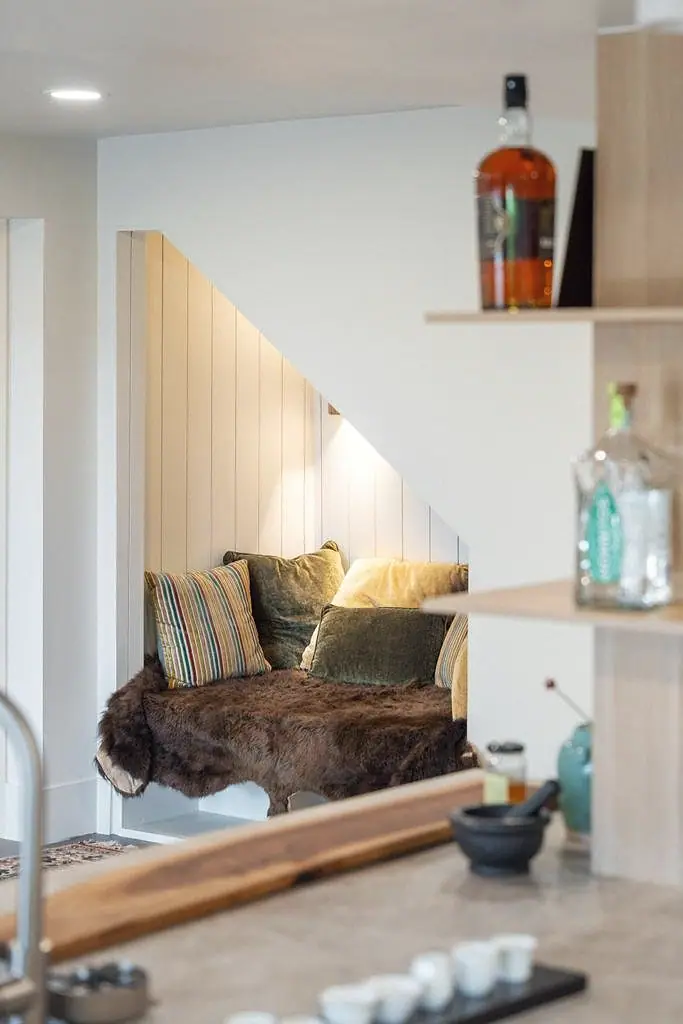 Crista da Montanha under-stair nook with fur throw, velvet pillows, and warm niche lighting