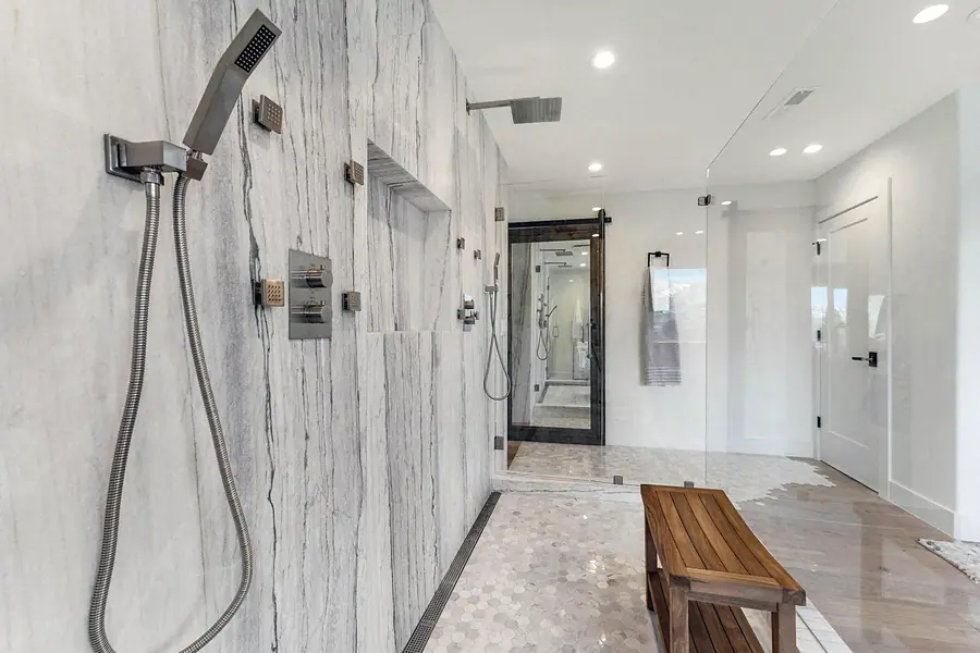Shower interior with handheld spray, body jets, and marble niche