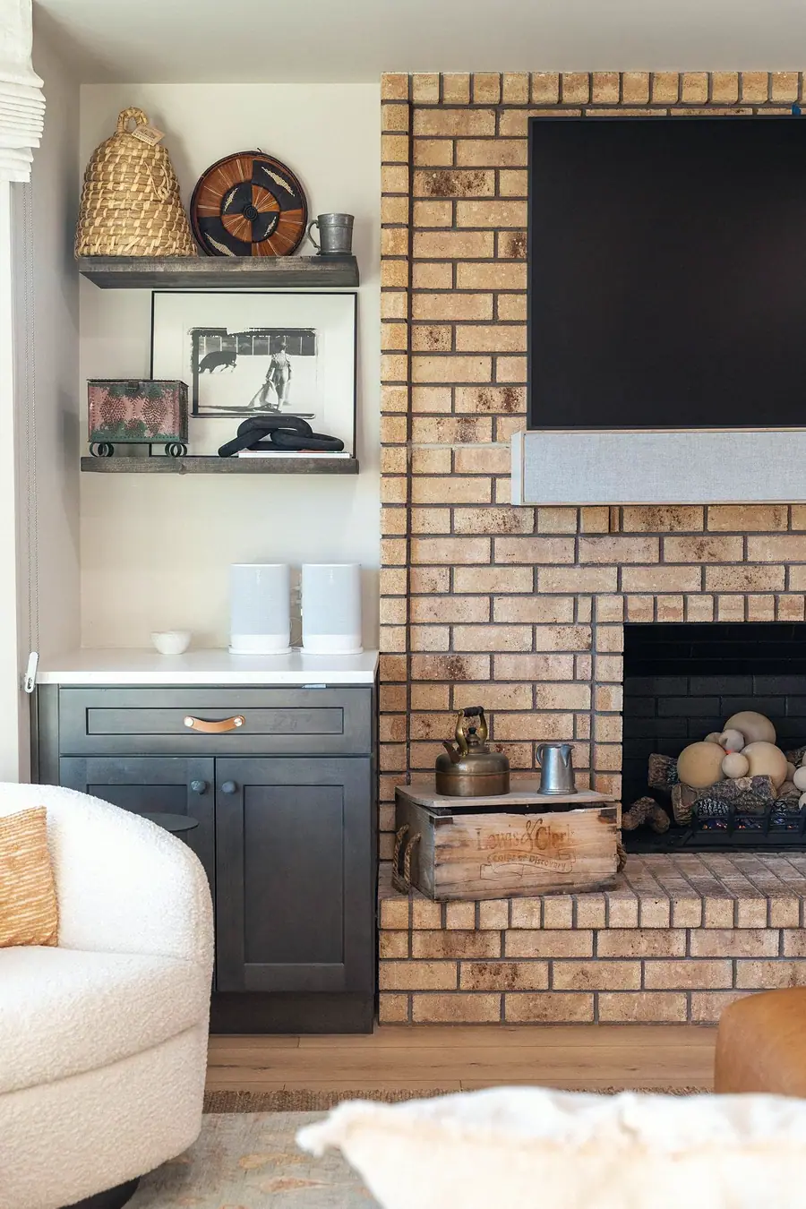 Midway fireplace detail with brick surround, built-in cabinets, and styled shelves