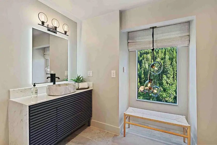 Matterhorn Hygge House vanity with marble vessel sink, glass pendant lights, and forest view