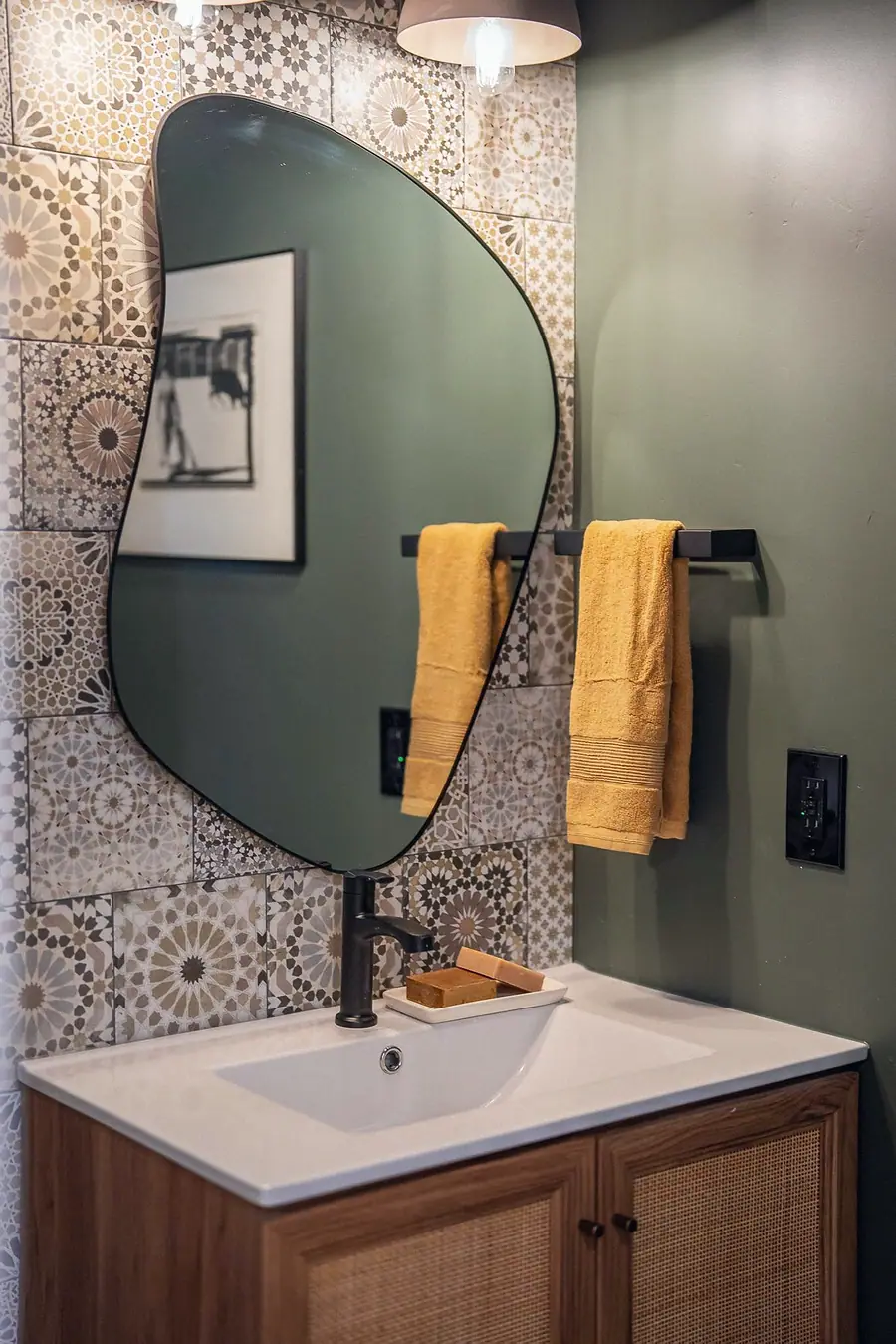 6468 S Brookstone powder room with patterned tile, organic mirror, and mustard towels