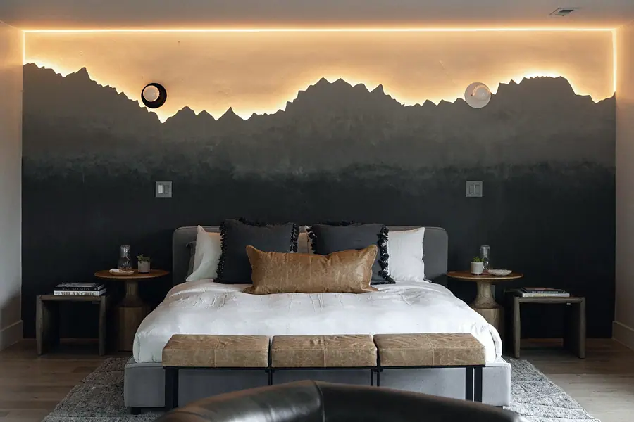 Matterhorn Hygge House bedroom with backlit mountain silhouette mural and layered bedding