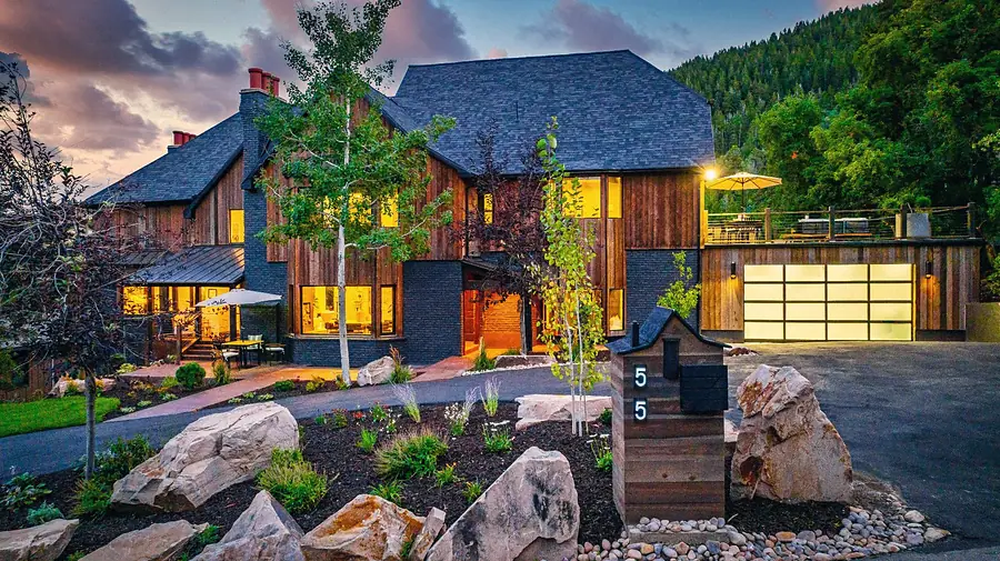 Matterhorn Hygge House driveway with house number 55 mailbox, glowing garage, and rooftop deck