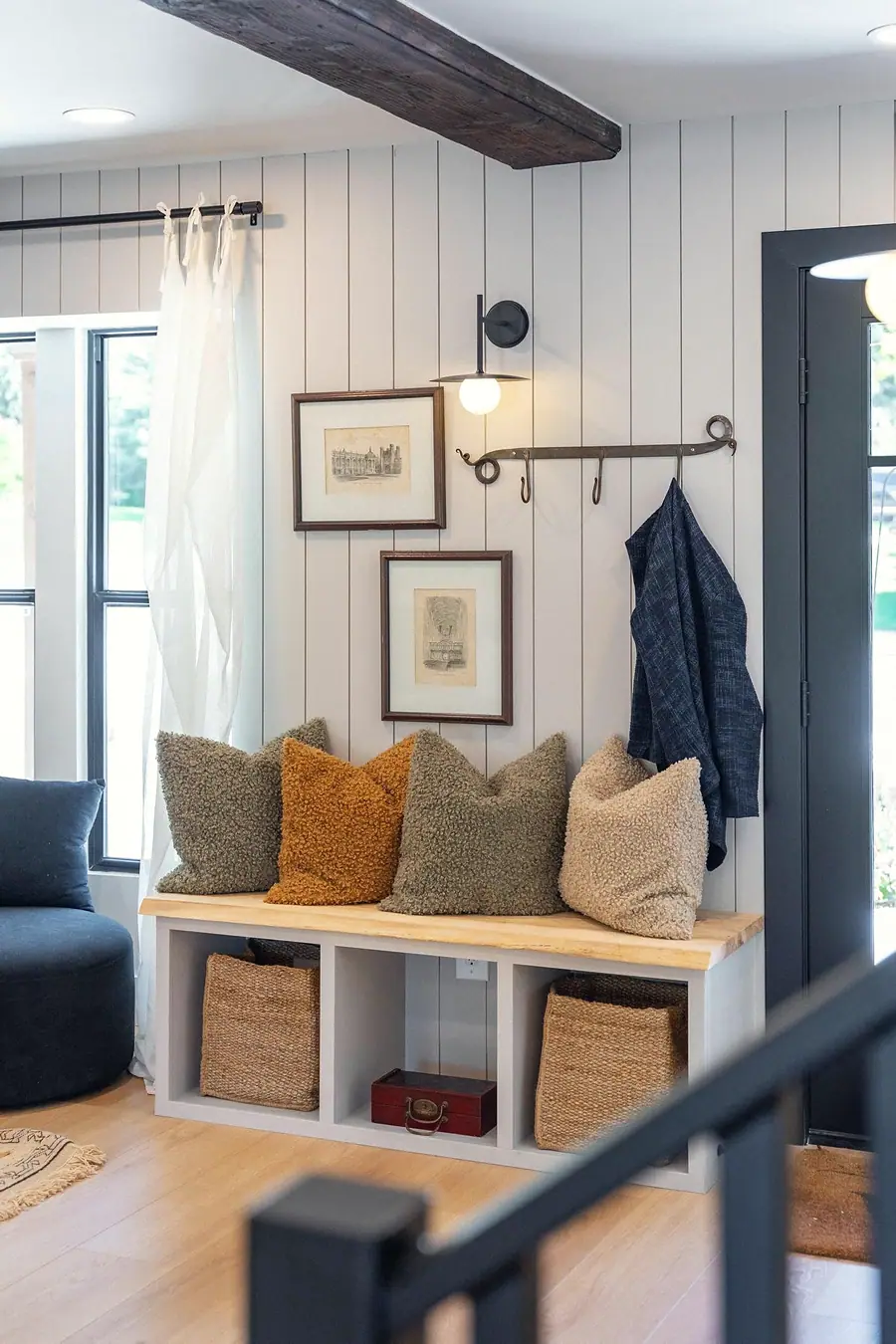 Little Gem mudroom bench with textured pillows, woven baskets, and coat hooks