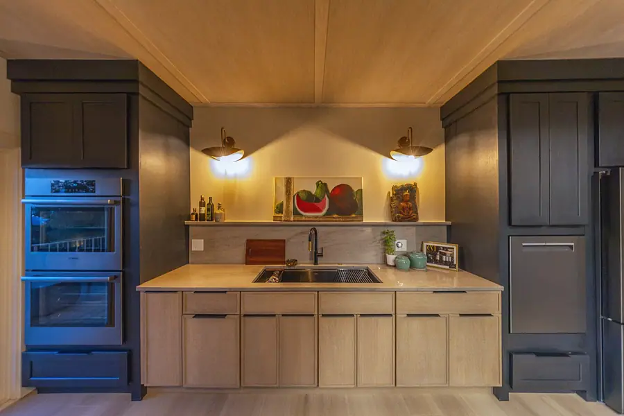 Lower living room with fireplace, green chairs, and built-in shelving