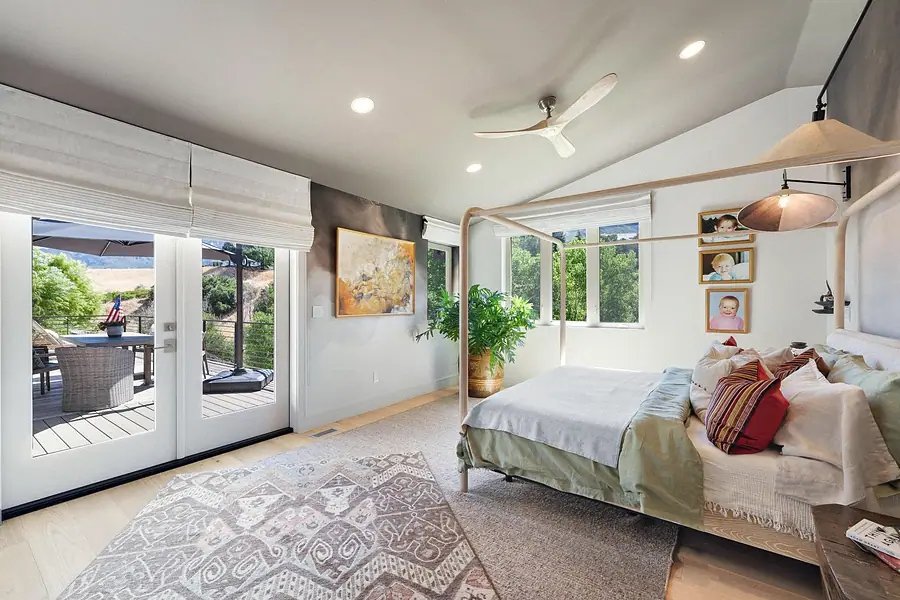 Elysium primary bedroom with canopy bed, deck doors, and mountain views