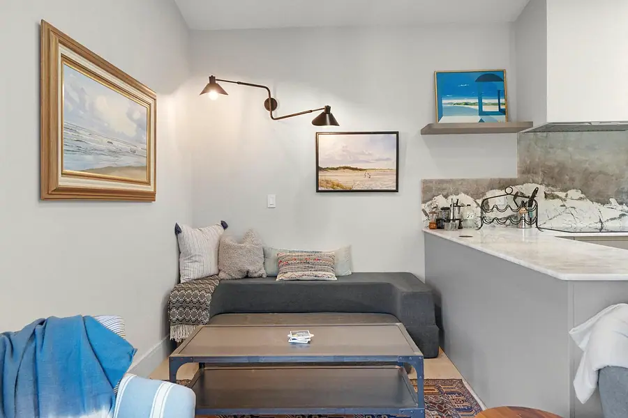 Elysium living nook with gray sofa, industrial coffee table, and coastal art