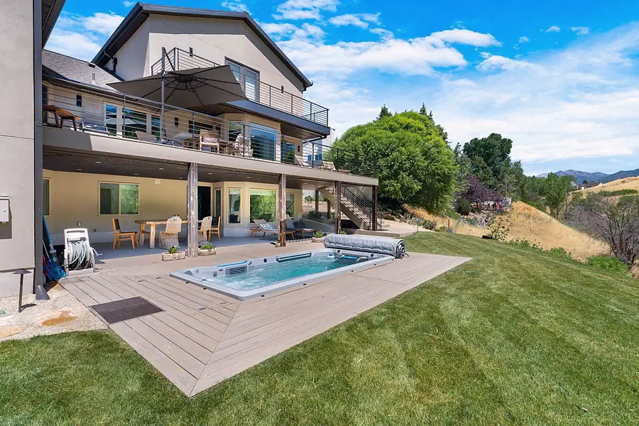 Elysium swim spa on deck with multi-level outdoor living and lawn