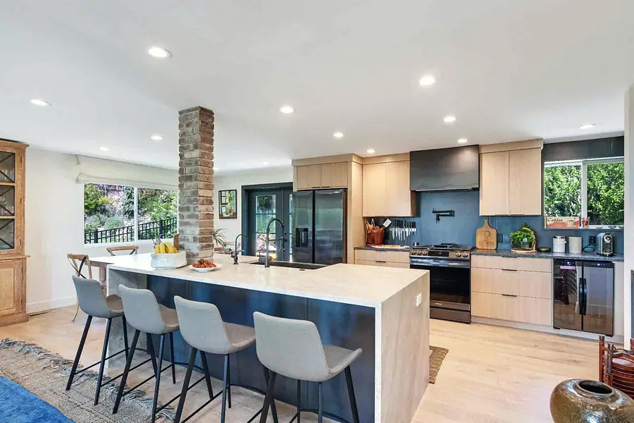 Wallace Project kitchen with light oak cabinets, stone island, and stainless appliances