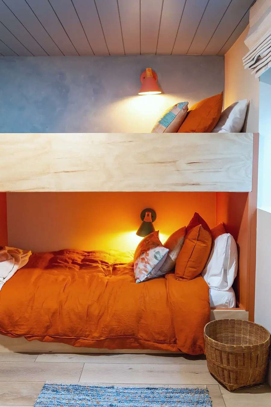 Midway built-in bunk nook with orange bedding, coral alcove, and warm reading lights