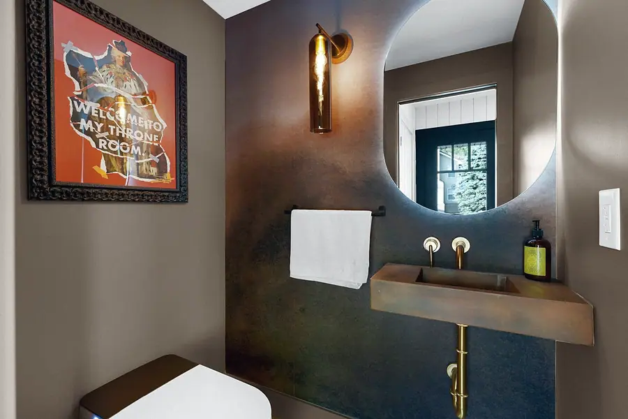 Little Gem powder room with copper trough sink and circular mirror