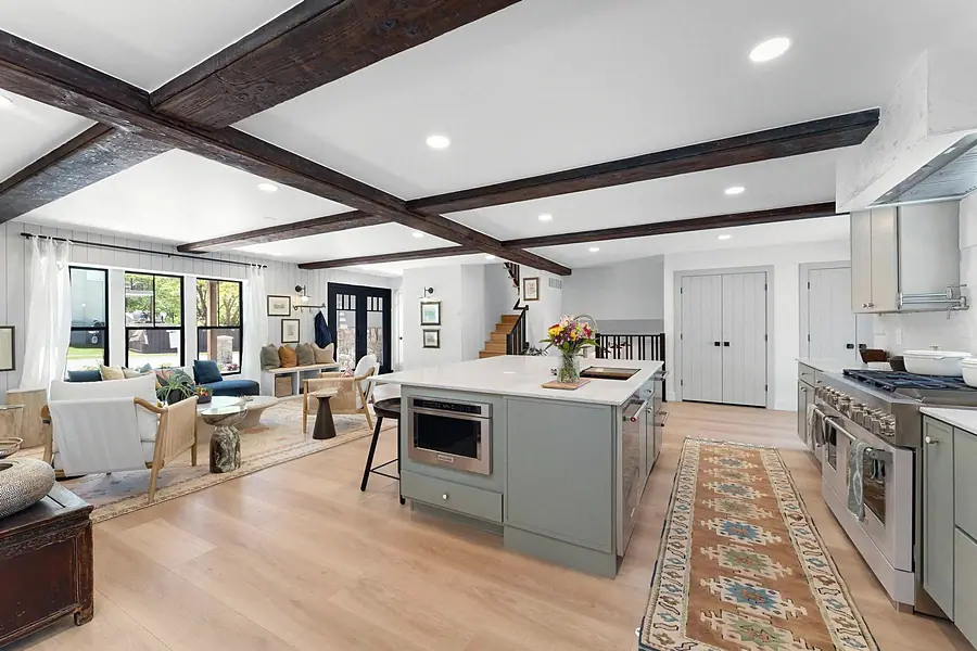 Little Gem open kitchen island, living room, and dark wood ceiling beams