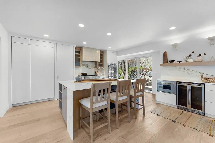 Grand Vista kitchen with marble island, light wood cabinetry, and dining counter