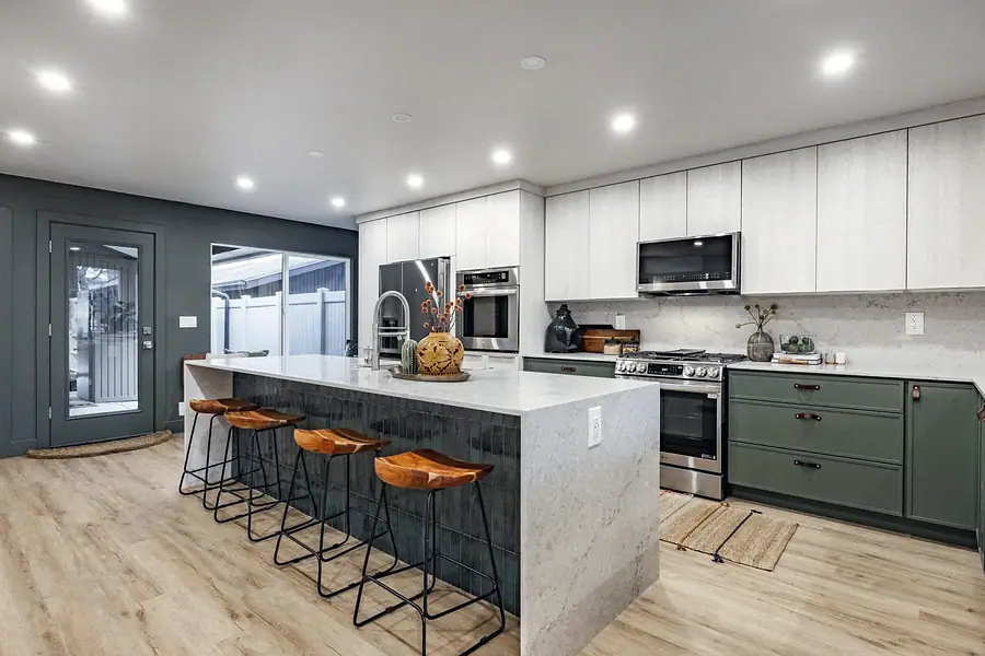 6468 S Brookstone kitchen island with wood stools looking toward range and patio doors