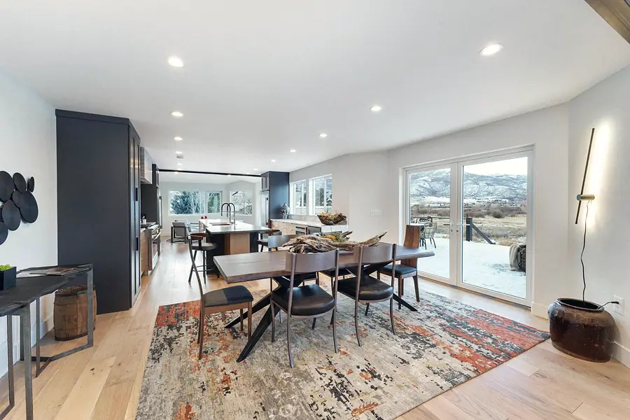 Open dining and kitchen with mountain views through glass doors