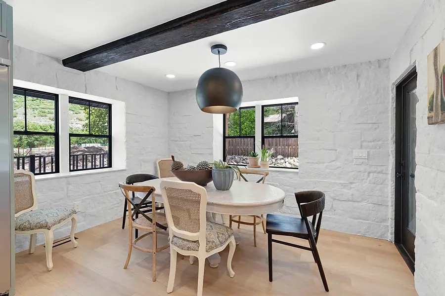 Little Gem dining room with white brick walls, round table, and globe pendant