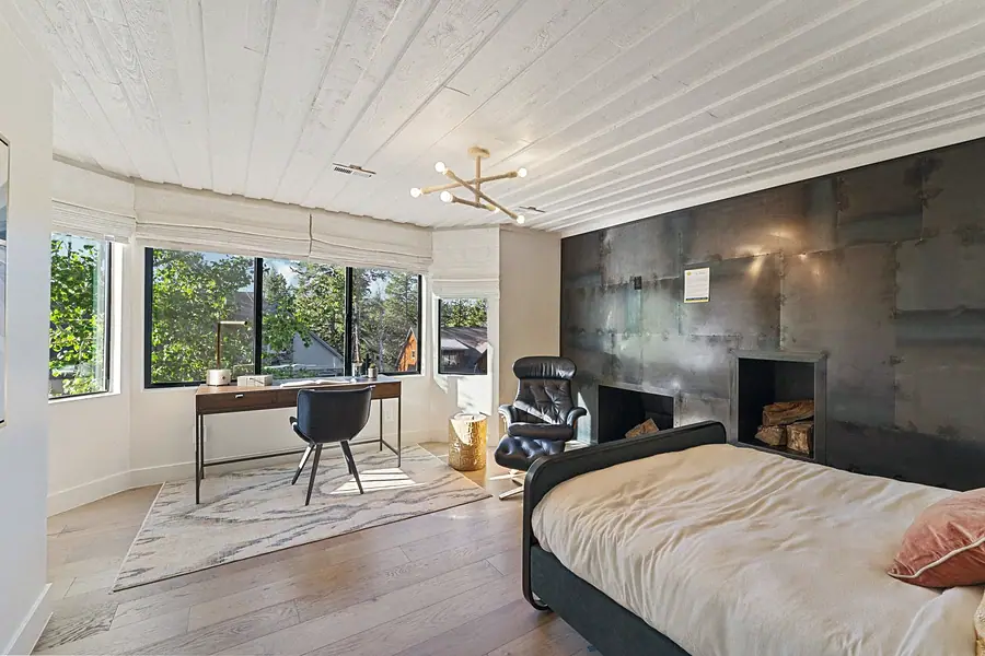 Matterhorn Hygge House bedroom with metal fireplace wall, desk workspace, and bay windows