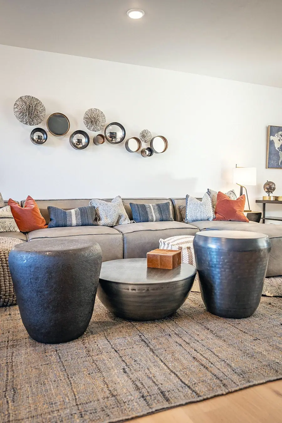 Silver Creek living room seating with metal drum tables and circular wall mirrors
