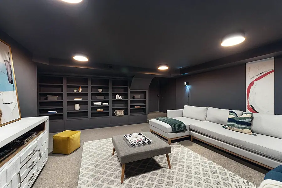 Fairway House basement living room with built-in dark bookshelves and media seating
