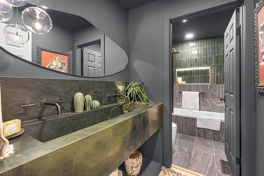 Crista da Montanha powder room with green marble trough sink opening to emerald-tiled bath