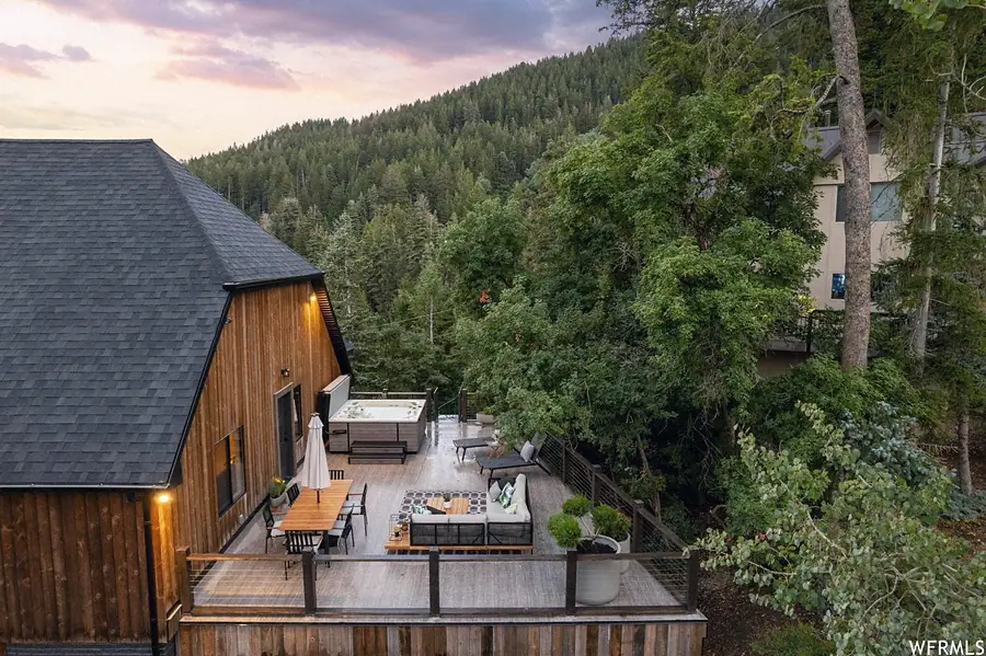 Matterhorn Hygge House aerial deck with outdoor dining, lounge seating, and hot tub at dusk