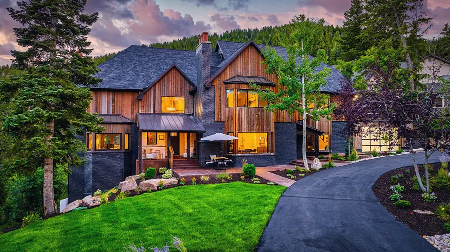 Matterhorn Hygge House front exterior at dusk with wood siding, glowing windows, and curved driveway