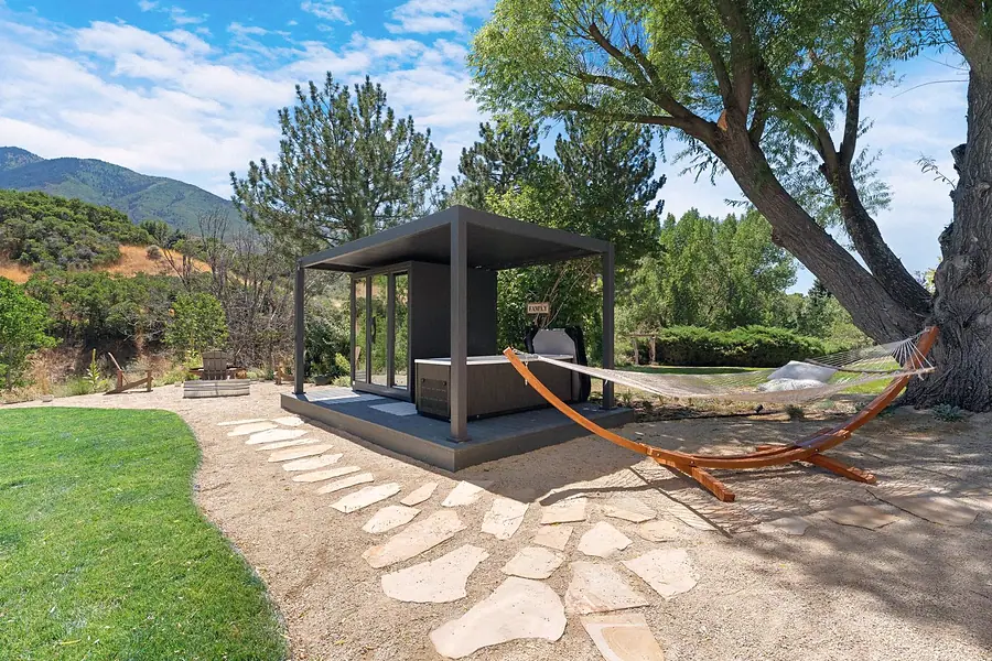 Elysium spa pavilion with hammock, hot tub, and fire pit area