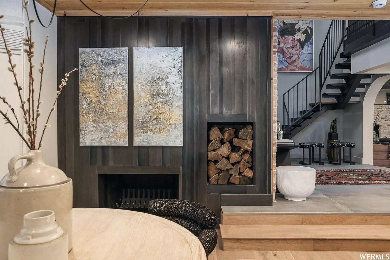 Styled dining room with a charred-wood fireplace wall and abstract art