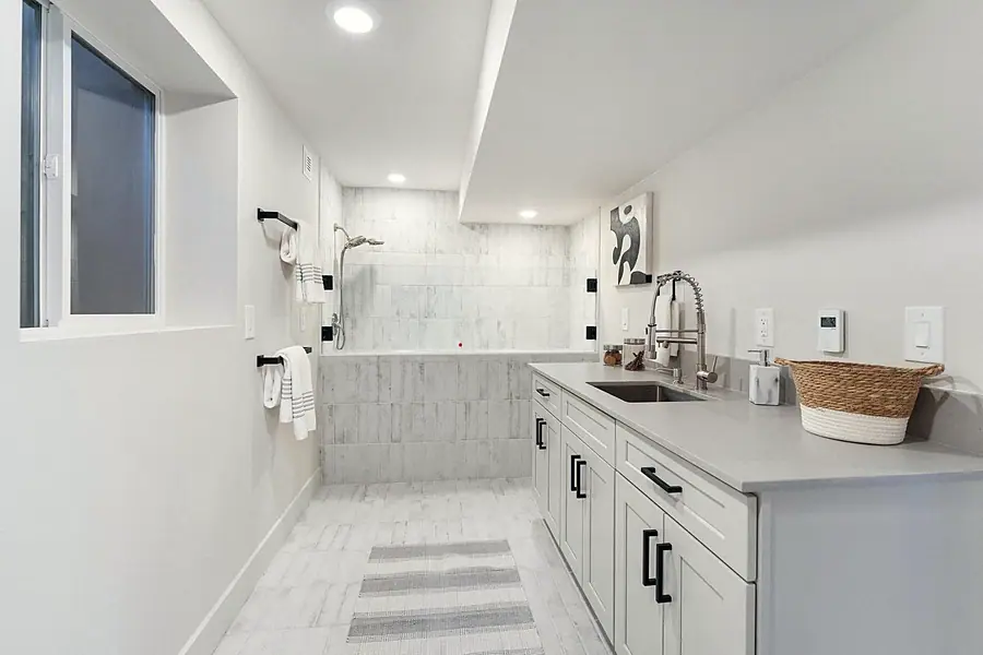 Fairway House spa bathroom with marble tile shower, freestanding tub, and long vanity