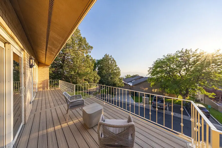Upper deck with woven chairs, mountain views, and golden-hour light