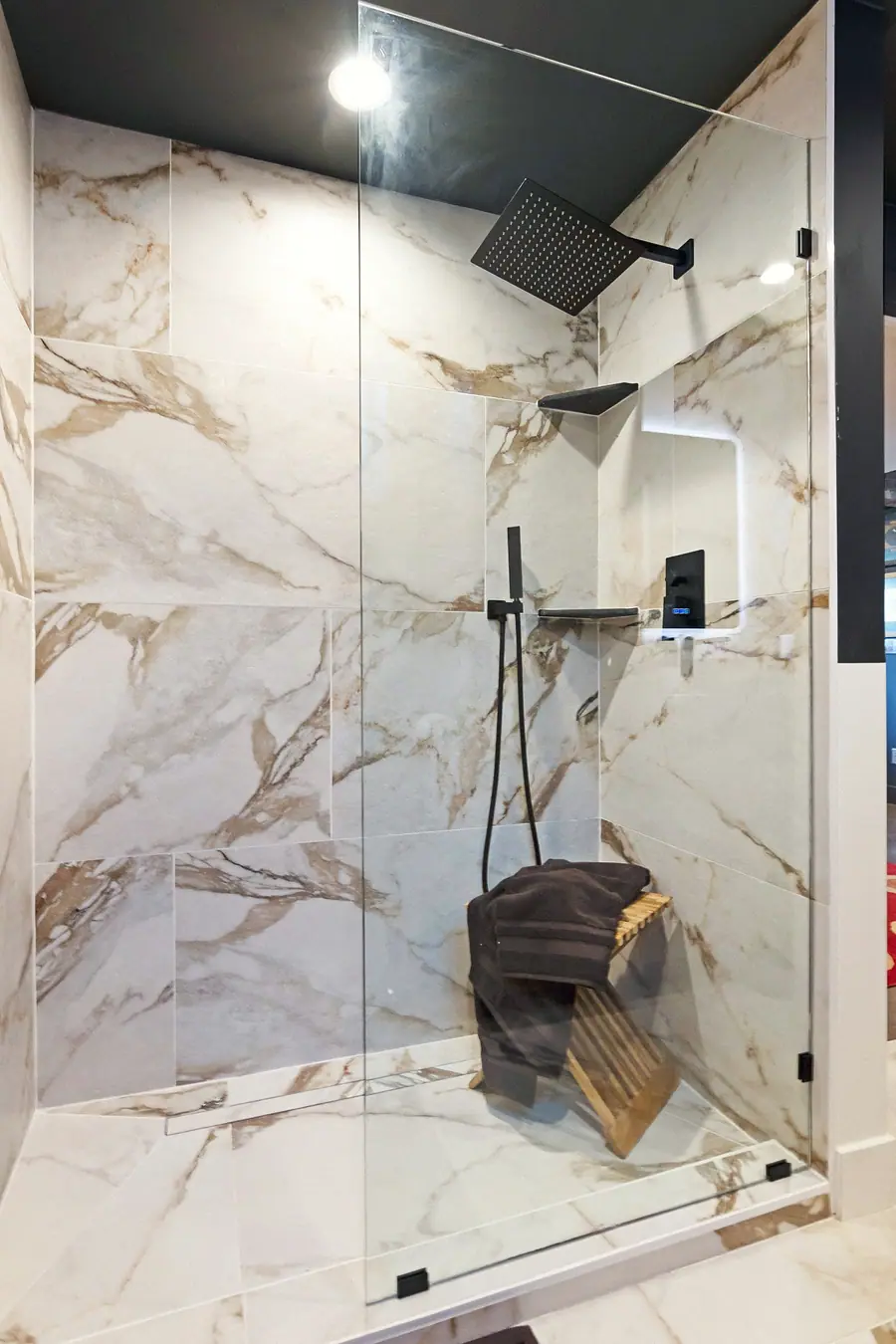 Wallace Project walk-in shower with marble tile, black fixtures, and glass enclosure