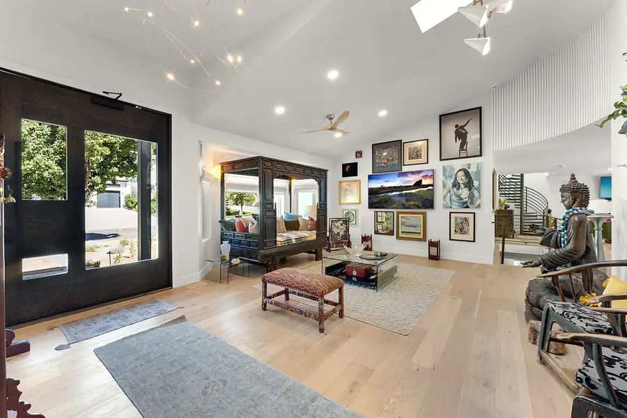 Elysium vaulted living room with canopy daybed, gallery wall, and bronze Buddha